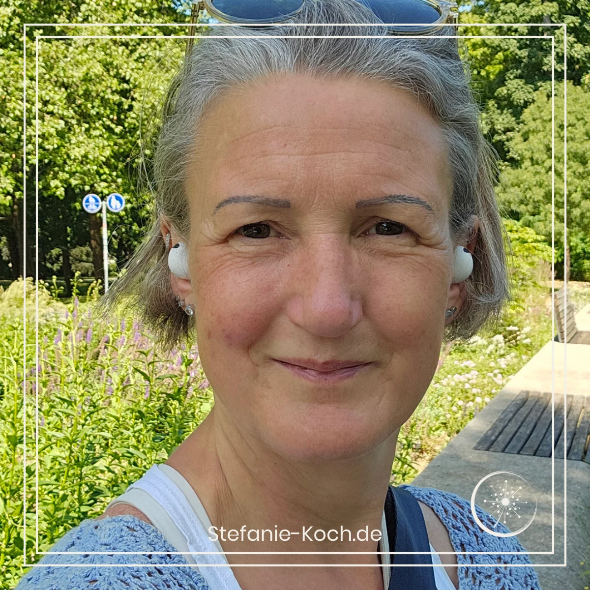 Frontalaufnahme einer Frau im Freien mit kleinen Earphones.