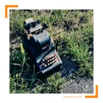 Eine alte Rechenmaschiene liegt im Grass