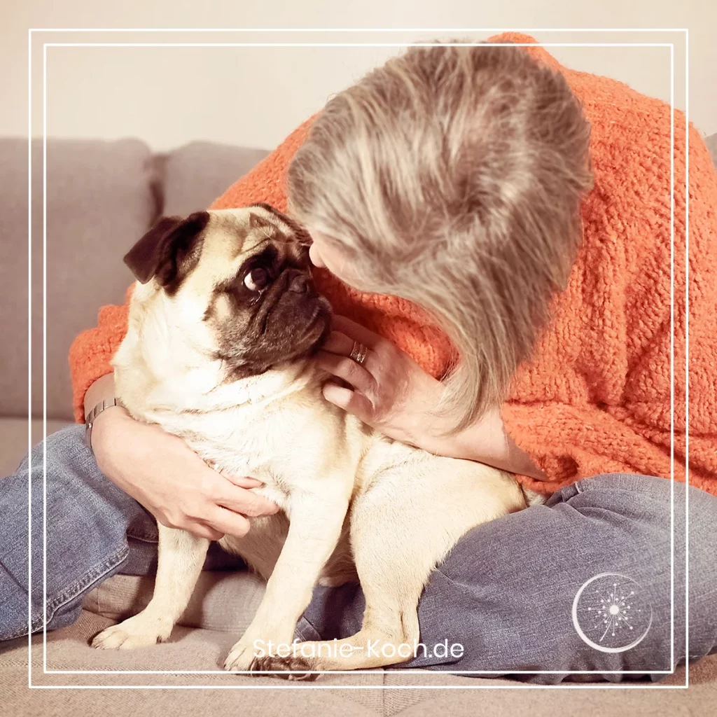 Die Blog-Autorin knuddelt mit ihrem Mopsbewohner auf der Couch.