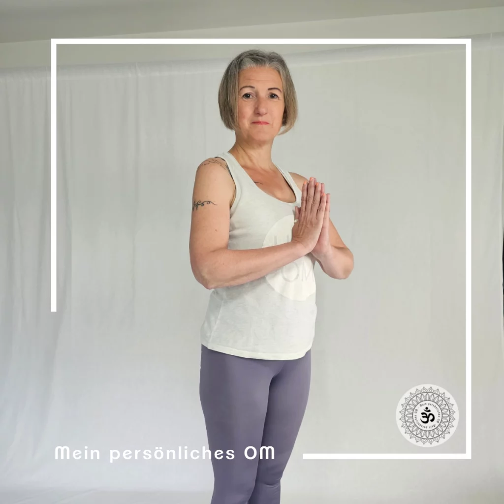 Frau steht in Yogapose - Tadasana vor einer weißen Wand.