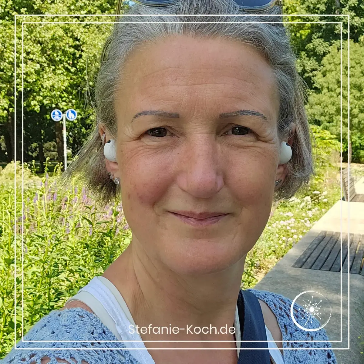 Das kann ich im Alter immer besser - Stefanie Koch im blauen Pullover mit In-Ears lächelt in die Kamera.