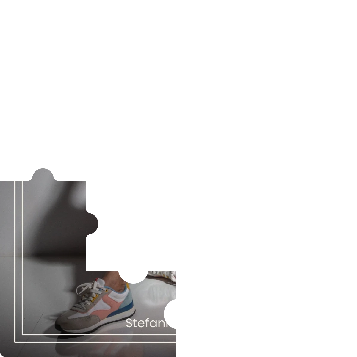 Puzzleteil eines Bildes - Frau sitzt in Jeans und orangefarbenen Pullover auf dem Fußboden.