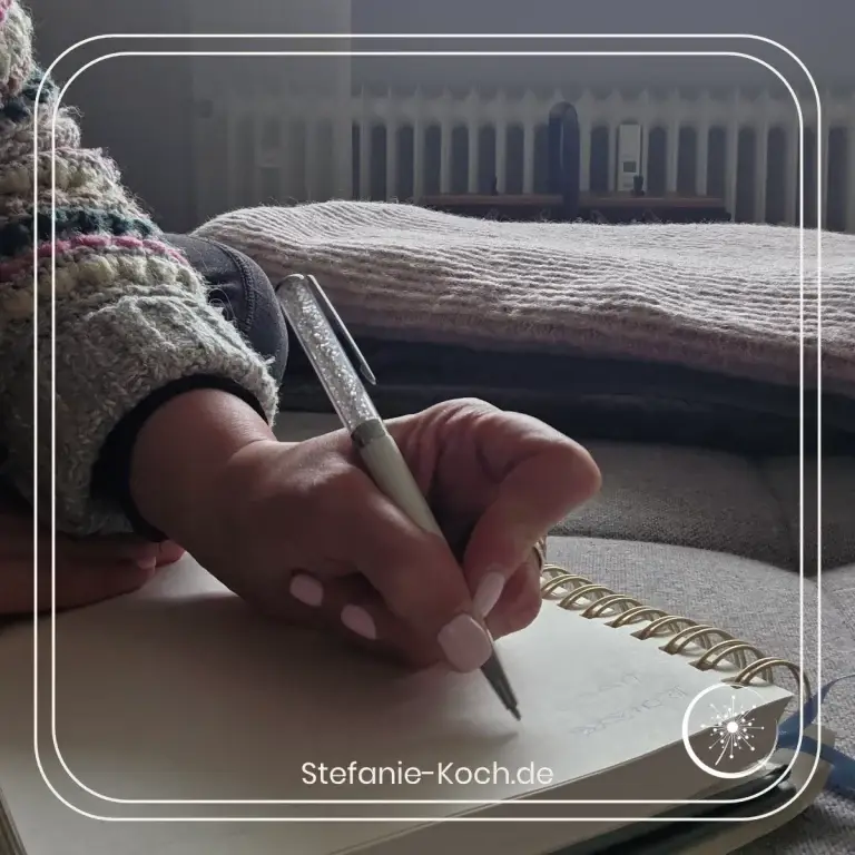 Hand mit Stift schreib in ein Notizbuch