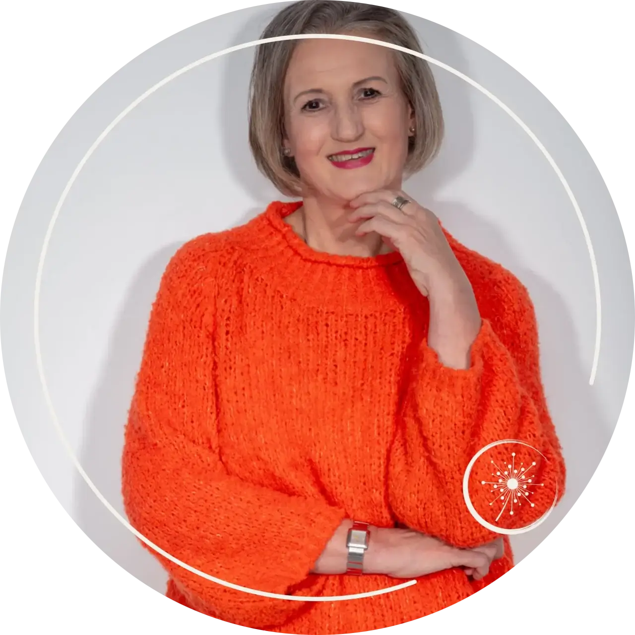 Verabschiedung - Stefanie Koch im oranefarbenen Pullover vor einer dunklen Wand lächelt in die Kamera.