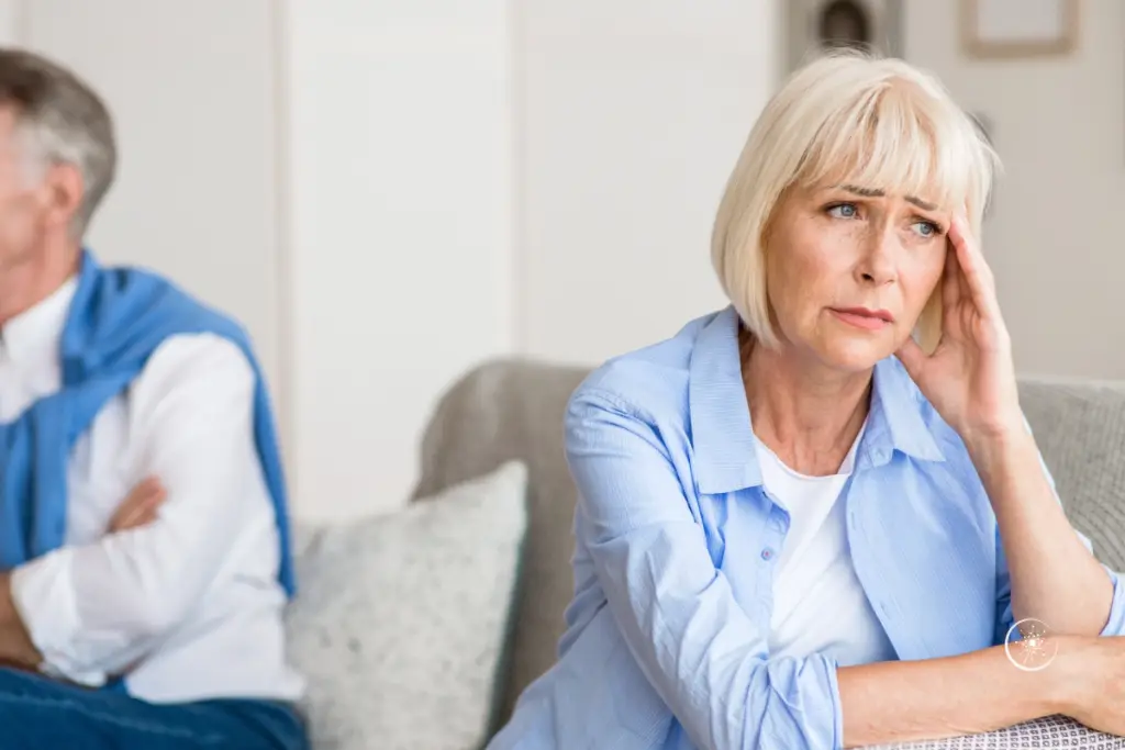 Was nicht sagen bei Depression: 10 Sätze, die wirklich wehtun - ein Paar sitz auf einem Sofa. Beide schauen in unterschiedliche Richtungen. sie sieht verzweifelt aus.
